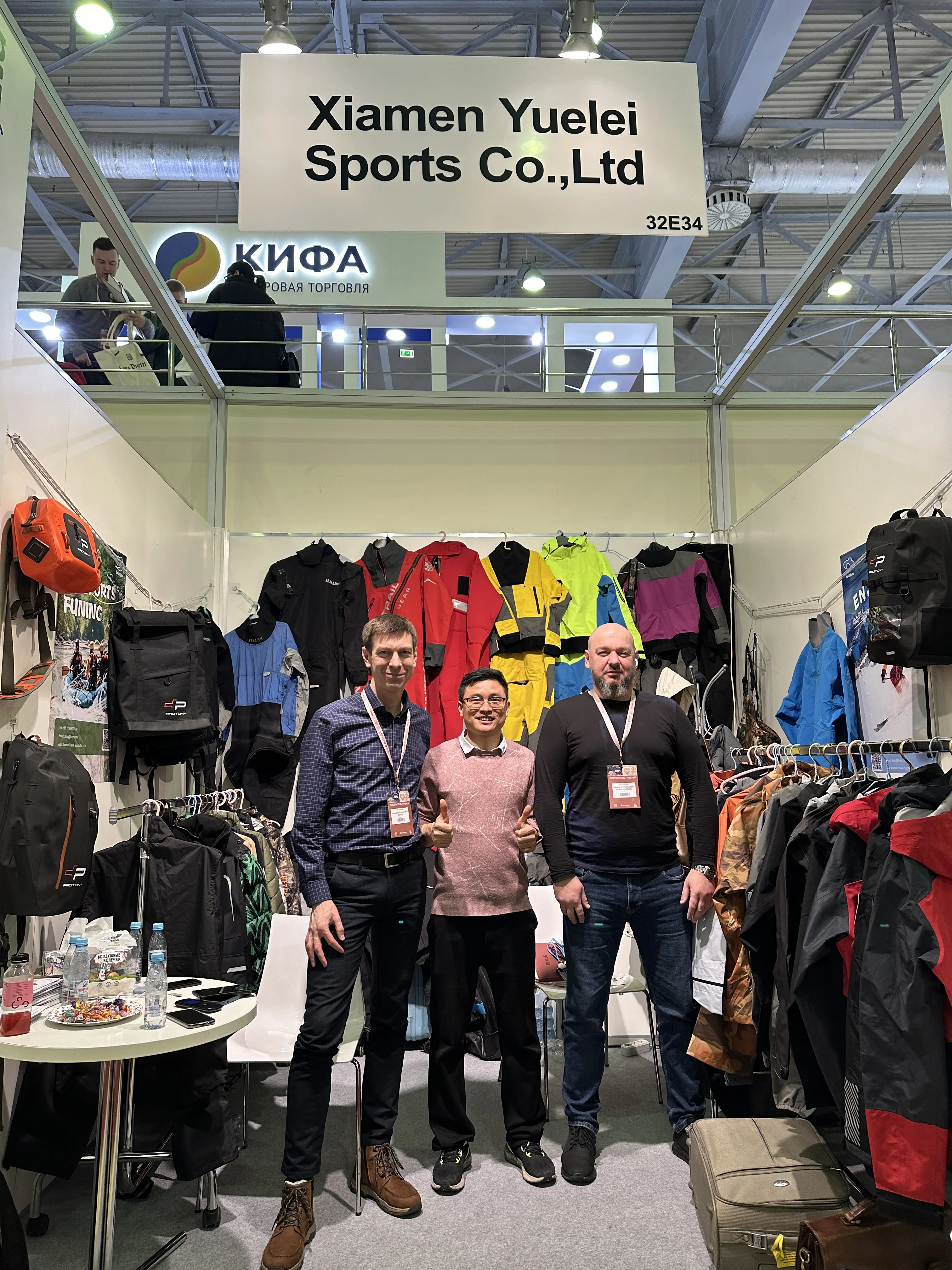 Trade show visitors discussing waterproof outdoor apparel